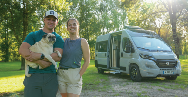 A couple with their dog in front of RV offering nomad tips