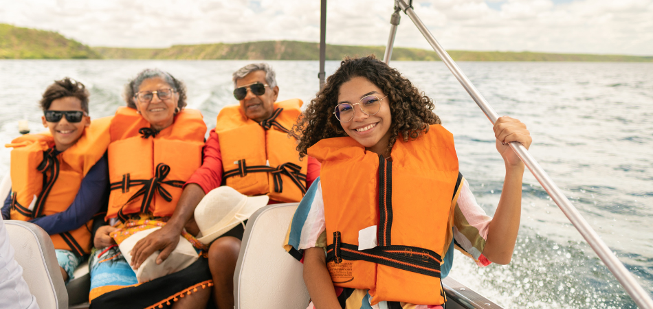 Boaters wearing life jackets while on a boat in the summer practising boat safety.