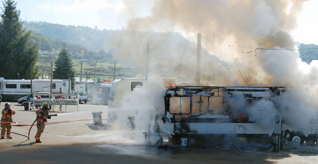 Firefighters spraying water at an RV on fire