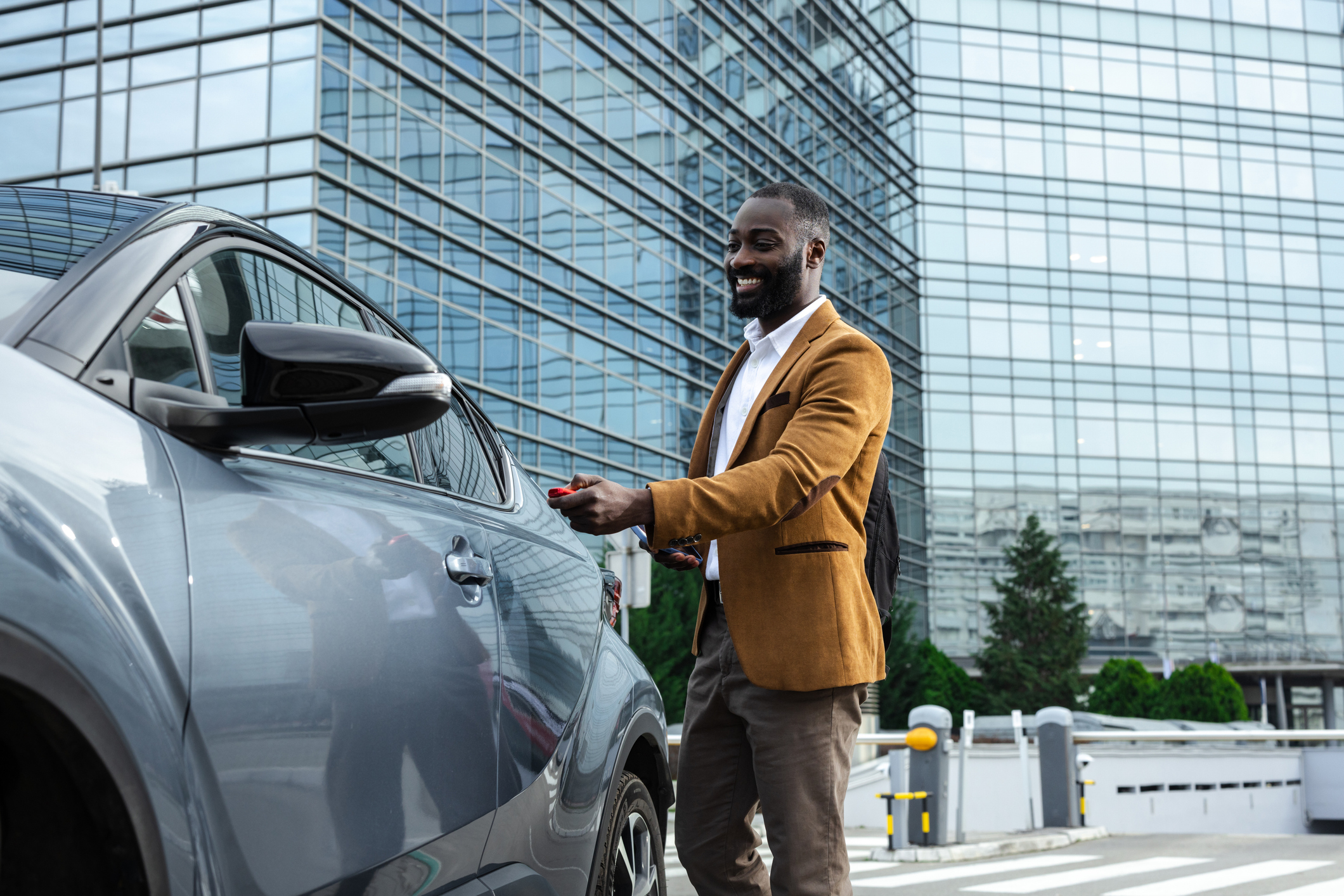 Man unlocking vehicle on city street