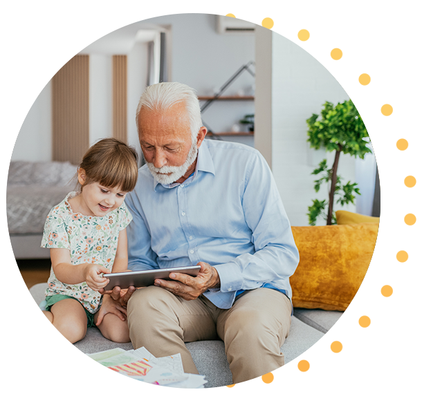 Mature man holding young children on lap outdoors in front of home