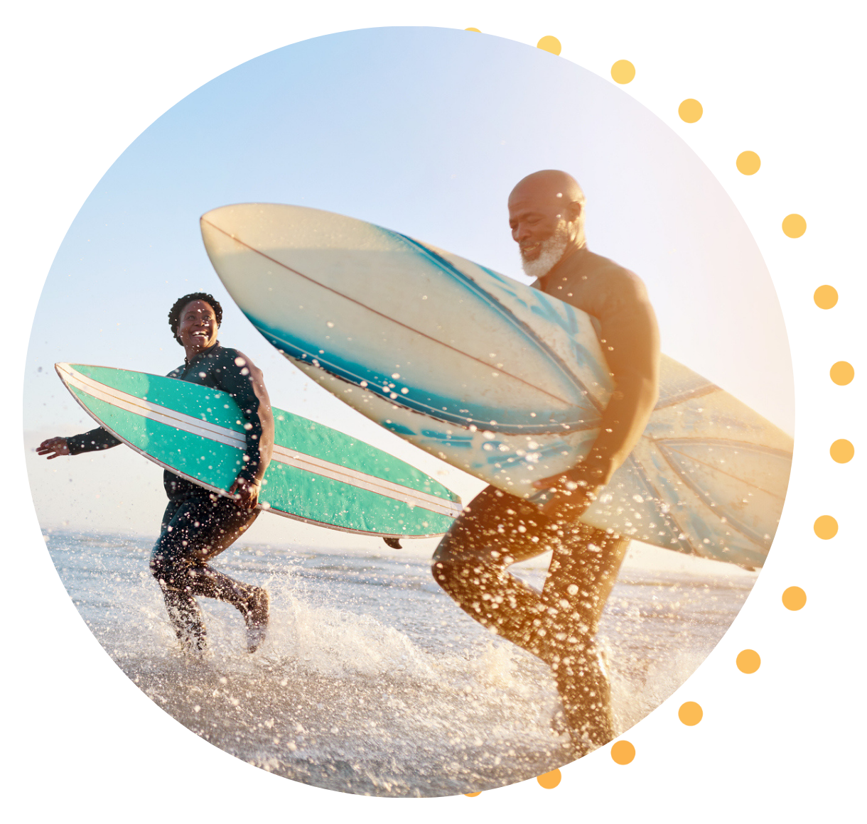 A Black couple in their early 50's running in the surf, carrying surfboards under their arms.