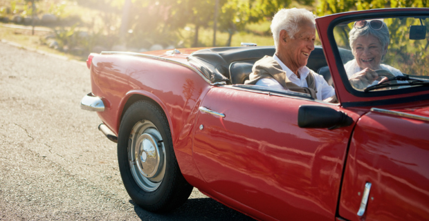 Image of a senior couple going on a road trip in their collector car during the summer. 