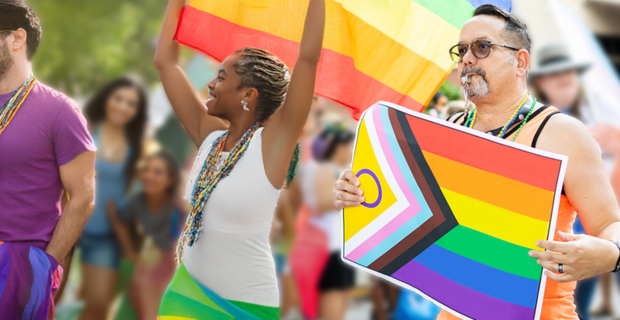 People walking with Pride Flags at a Pride parade.