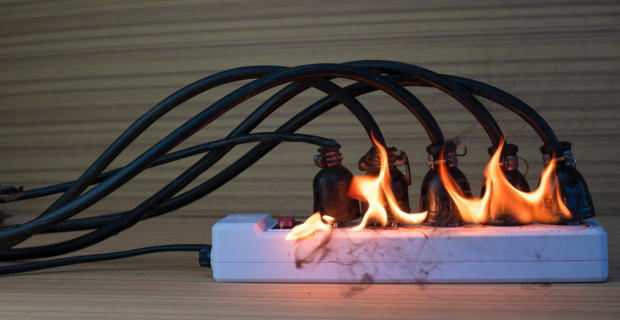 Image shown of an overloaded power bar catching fire because of misuse and lack of electrical fire safety.