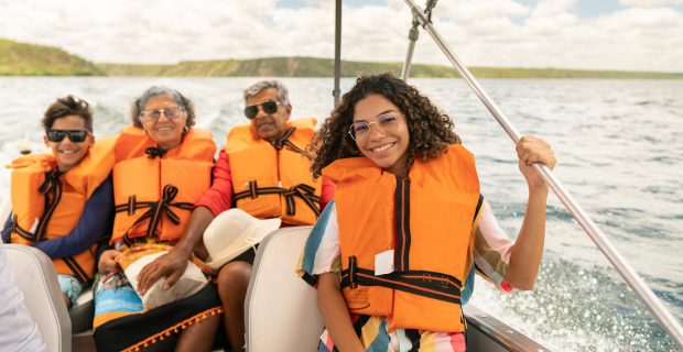 Boaters wearing life jackets while on a boat in the summer practising boat safety.