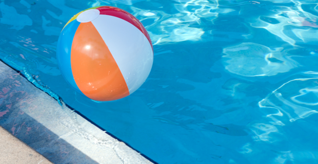 Beach ball floating on top of the water in a pool.